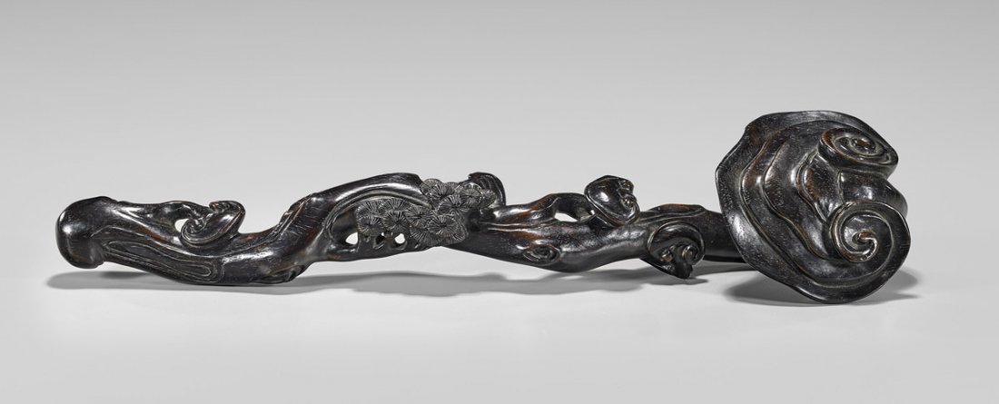 CARVED HARDWOOD RUYI SCEPTER: Chinese carved hardwood scepter; of naturalistic branch form with design of lingzhi fungus and pine branches in relief; L: 16 1/2"