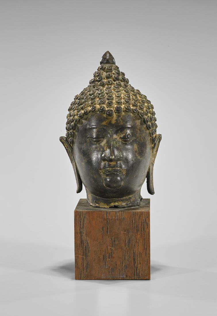 Antique Thai Bronze Head of Buddha: Antique Thai bronze head of Buddha; with well-cast facial features, elongated earlobes and snail curl hair; H: 5 1/4"; wood plinth