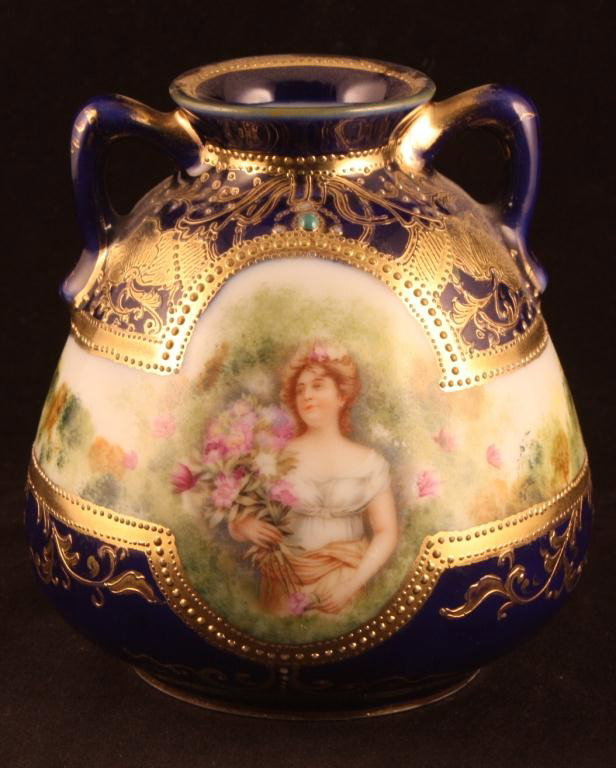 NIPPON Cobalt Portrait Vase of Woman with Flower: 4 1/2" tall. Gold scroll work over cobalt body. Mark 52. Plate 4341 (seventh series.) Good condition with gold loss to handles and rim and spider crack in bottom of vase. Nice green jewel at top of po