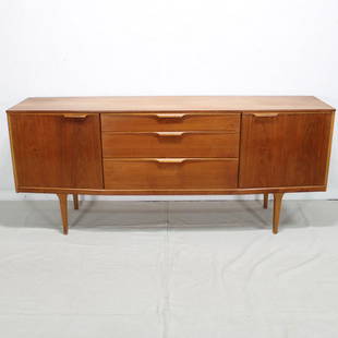 Teak Mid Century Modern Sideboard: This Danish modern style credenza is from England. It features three drawers to the center flanked by a door on each side. 31 tall x 73 long x 20 deep