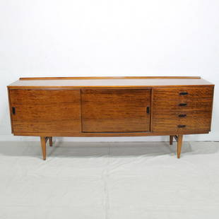 British Mid Century Modern Sideboard - Sliding Doors: This Danish modern style credenza is from England. It features four drawers to the right with two sliding doors to the left. 31 tall x 79 long x 19 deep. The wood has a nice glow to it, possibly