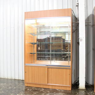 Store Display Cabinet: This illuminated store display cabinet has 4 adjustable glass shelves. Has two glass doors on top, with a storage compartment with two sliding doors on bottom, no key. 85in tall x 53 in wide x 21 in