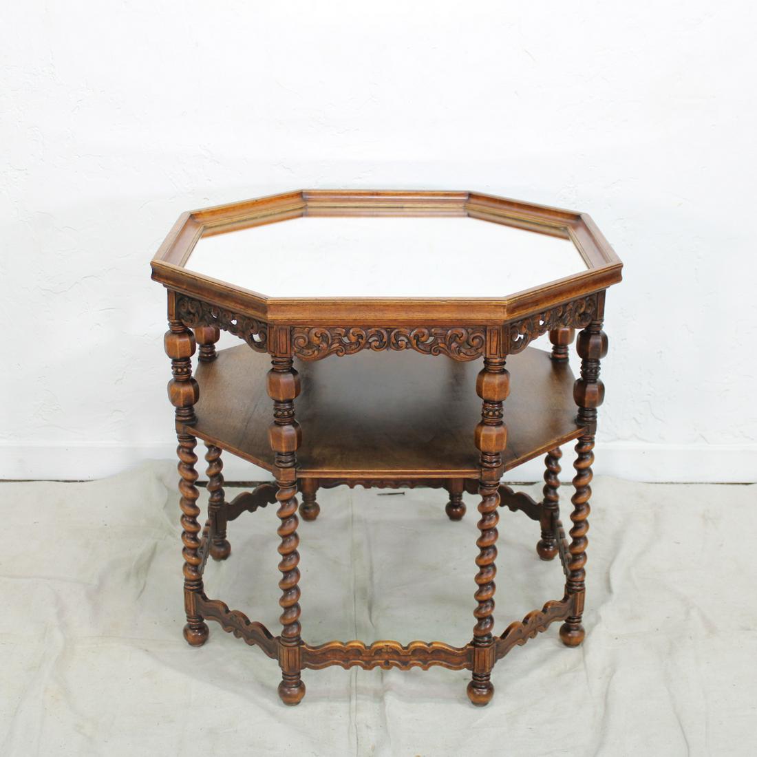 Octagon Shaped Table: This table is perfect as a tall coffee table or a side table, had a mirrored top surface, carved apron, a shelf and barley twist legs.