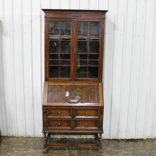 Barley Twist Drop Front Secretary Bookcase: This British Drop Front Bureau Bookcase has paneled glass to the top. The drop down section is heavily carved on the outside. The inside is fully fitted with a brown leather surface. 85in tall x 38