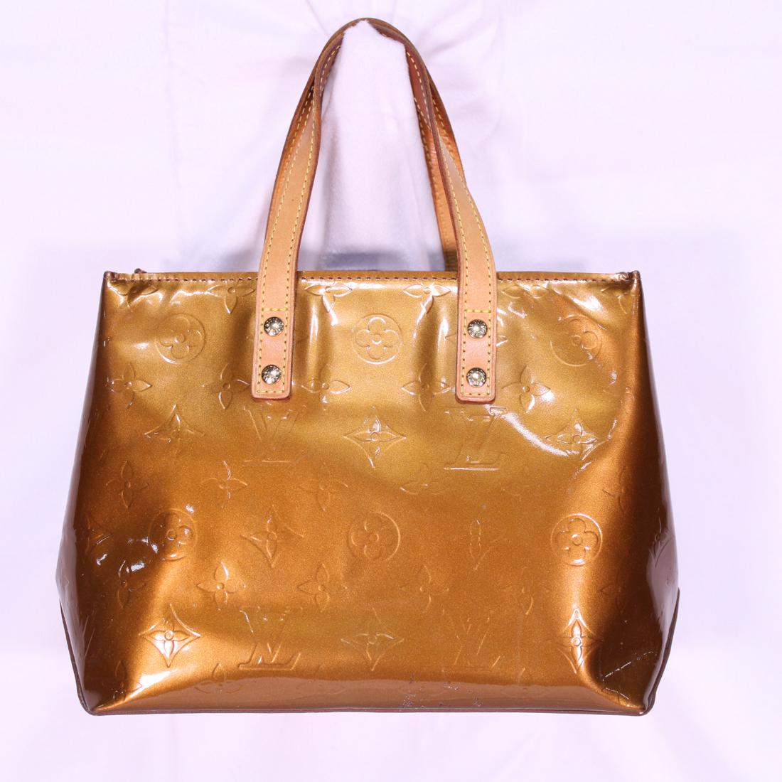 Louis Vuitton Reade PM in Monogram Vernis: Genuine Pre-Owned Louis Vuitton Reade PM in Bronze Monogram Vernis in A condition. Date Code is MI0043France. Includes Dustbag. This lot includes a certificate of authenticity.