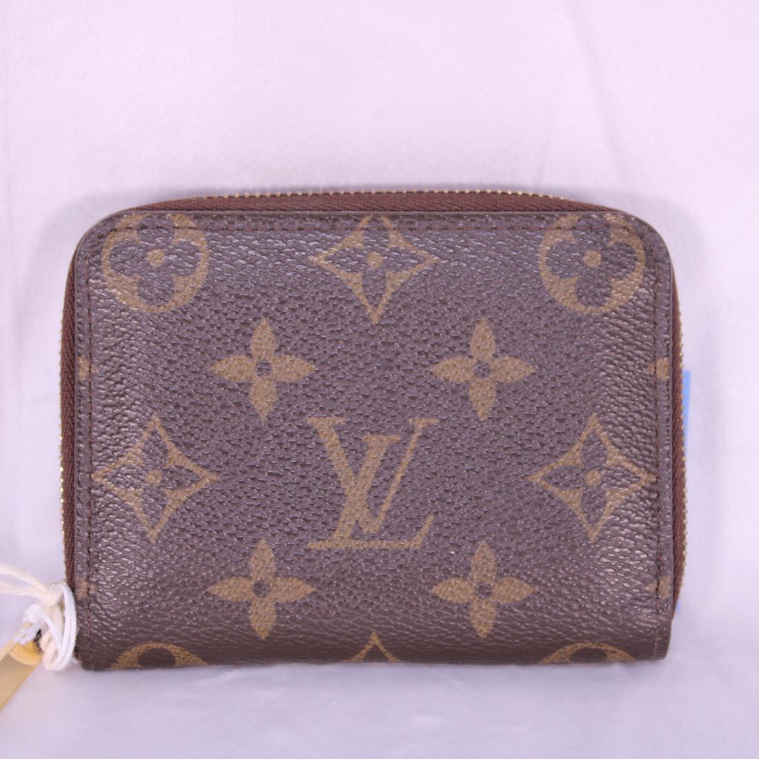 Louis Vuitton Zippy Coin Purse in Monogram Canvas: Genuine Pre-Owned Louis Vuitton Zippy Coin Purse in Brown Monogram Canvas in A condition. Date Code is SN3182. Measurements: 11*8*2cm (Length * Height * Width). This lot includes a certificate of auth