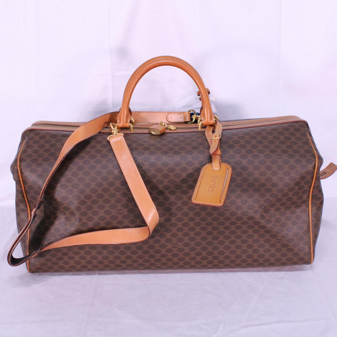 Celine Vintage Boston Bag 50 in Macadam Coated Canvas: Genuine Pre-Owned Celine Vintage Boston Bag 50 in Brown Macadam Coated Canvas in A condition. Date Code is M94. Includes Luggage Tag, Cadenas, Keys on Clochette, Strap. Measurements: 50*27*20cm (Lengt