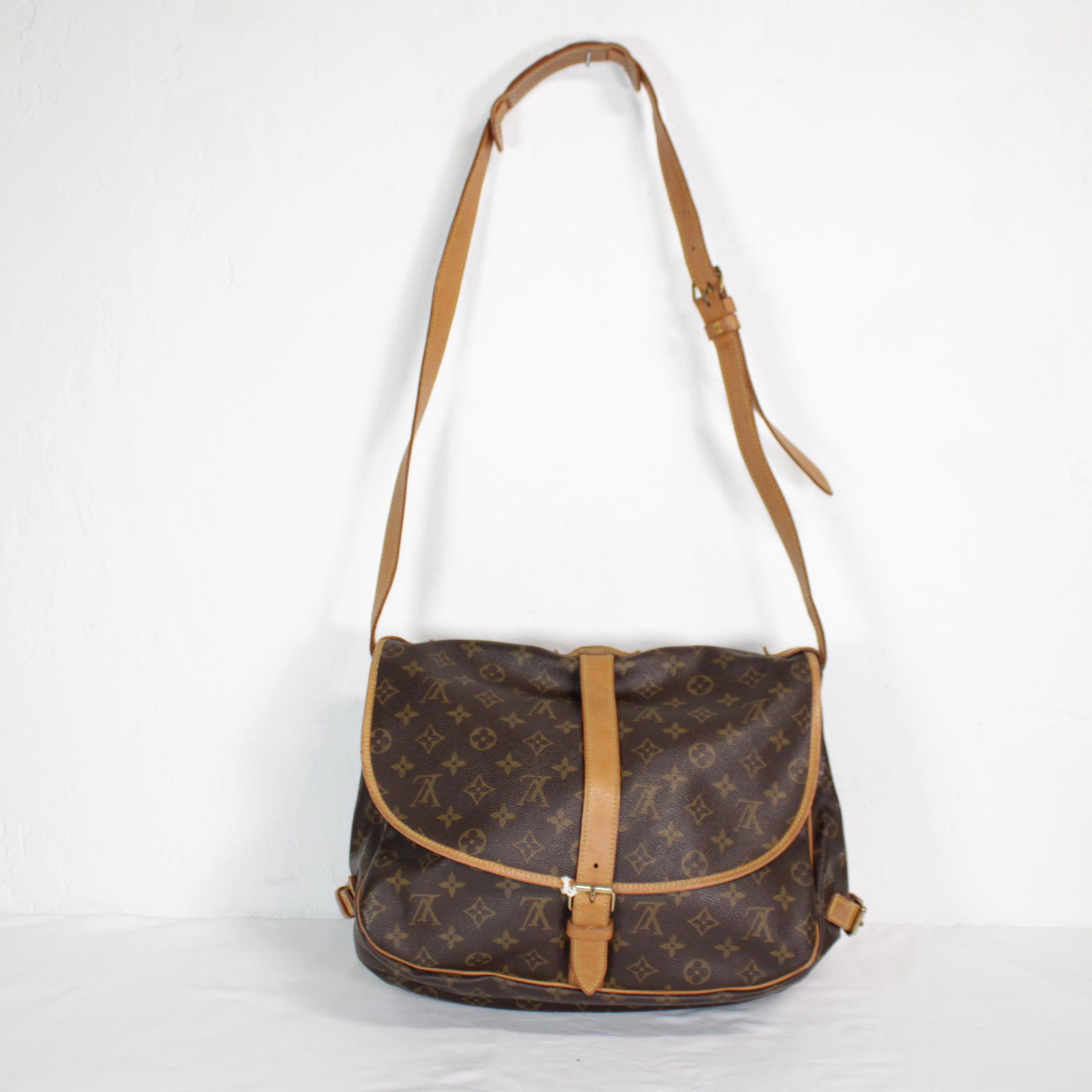 Louis Vuitton Saumur 30 in Monogram Canvas: Genuine Pre-Owned Louis Vuitton Saumur 30 in Brown Monogram Canvas in AB condition. Date Code is AR1921. Measurements: 30*27*17 (Length * Height * Width). This lot includes a certificate of authentici