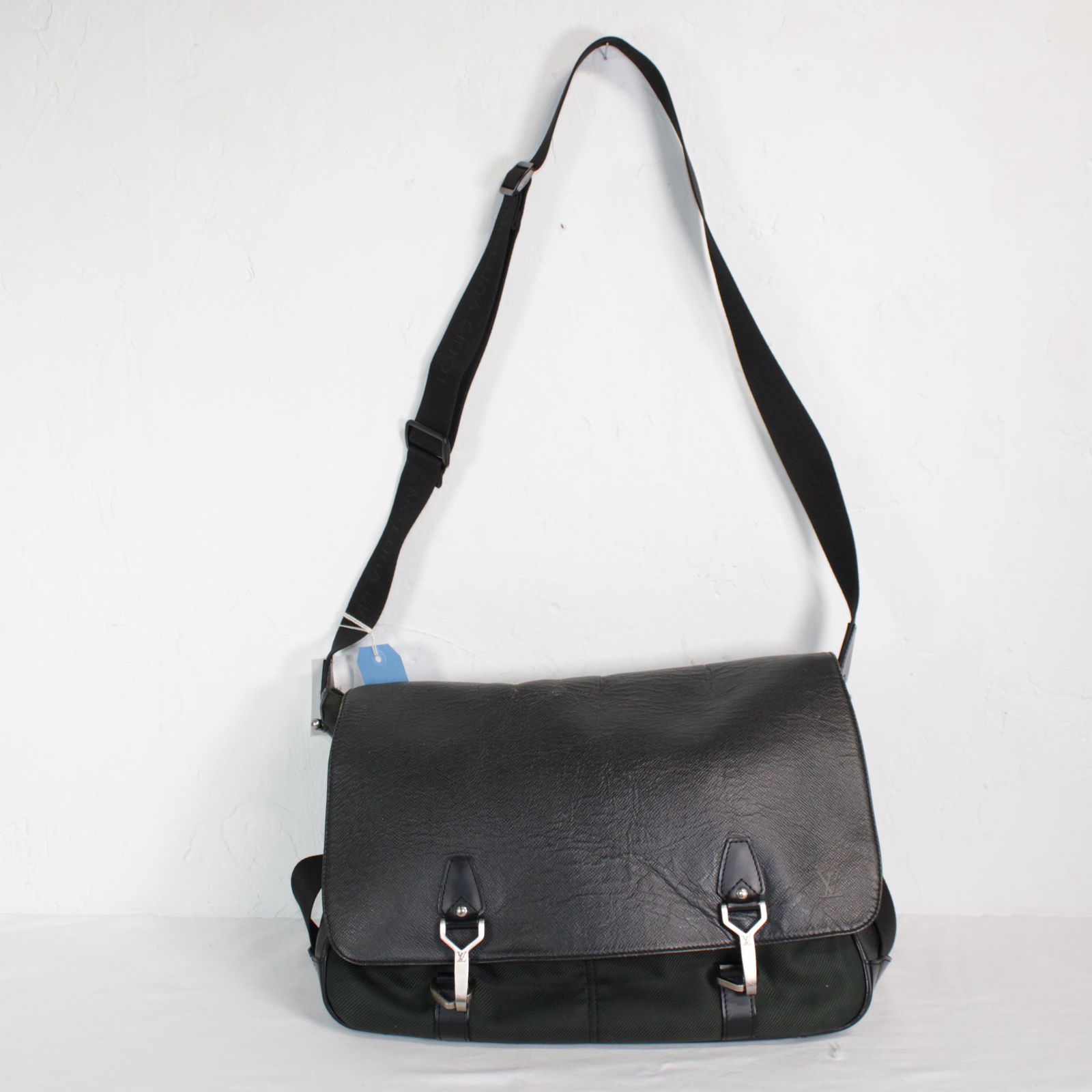 Louis Vuitton Dersou in Black Canvas Taiga Leather: Genuine Pre-Owned Louis Vuitton Dersou in Dark Green Taiga Leather in AB condition. Date Code is CE1025. Measurements: 40*35*10cm (Length * Height * Width). This lot includes a certificate of authenti