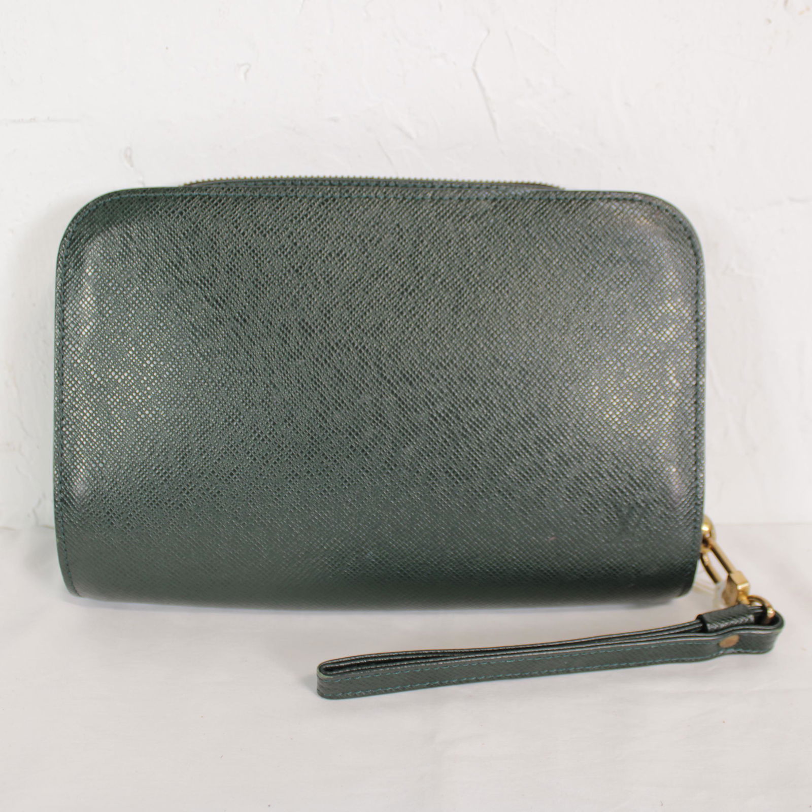 Louis Vuitton Pochette Baikal in Taiga: Genuine Pre-Owned Louis Vuitton Pochette Baikal in Green Taiga in AB condition. Date Code is VI1918. Measurements: 25*17*4cm (Length * Height * Width). This lot includes a certificate of authenticity.