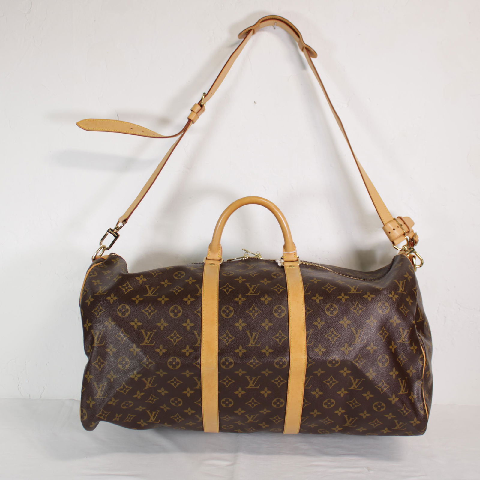 Louis Vuitton Keepall Bandouliere 55 in Monogram Canvas: Genuine Pre-Owned Louis Vuitton Keepall Bandouliere 55 in Brown Monogram Canvas in A condition. Date Code is MB0061 This lot includes Luggage Tag, Handle Strap, Strap. Measurements: 55*28*25cm (Lengt