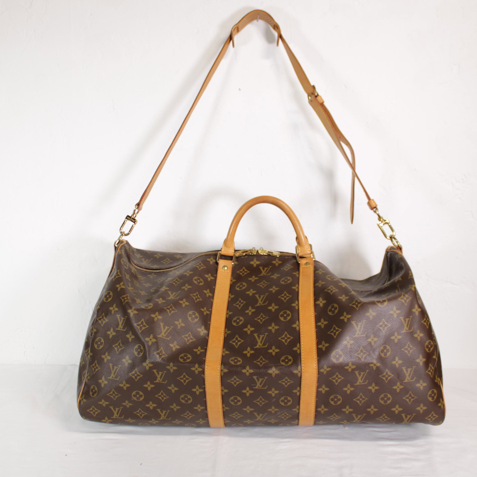 Louis Vuitton Keepall Bandouliere 60 in Monogram Canvas: Genuine Pre-Owned Louis Vuitton Keepall Bandouliere 60 in Brown Monogram Canvas in A condition. Date Code is VI0974 This lot includes Strap, Luggage Tag, Handle Strap, Cadenas, Keys. Measurements: 60*