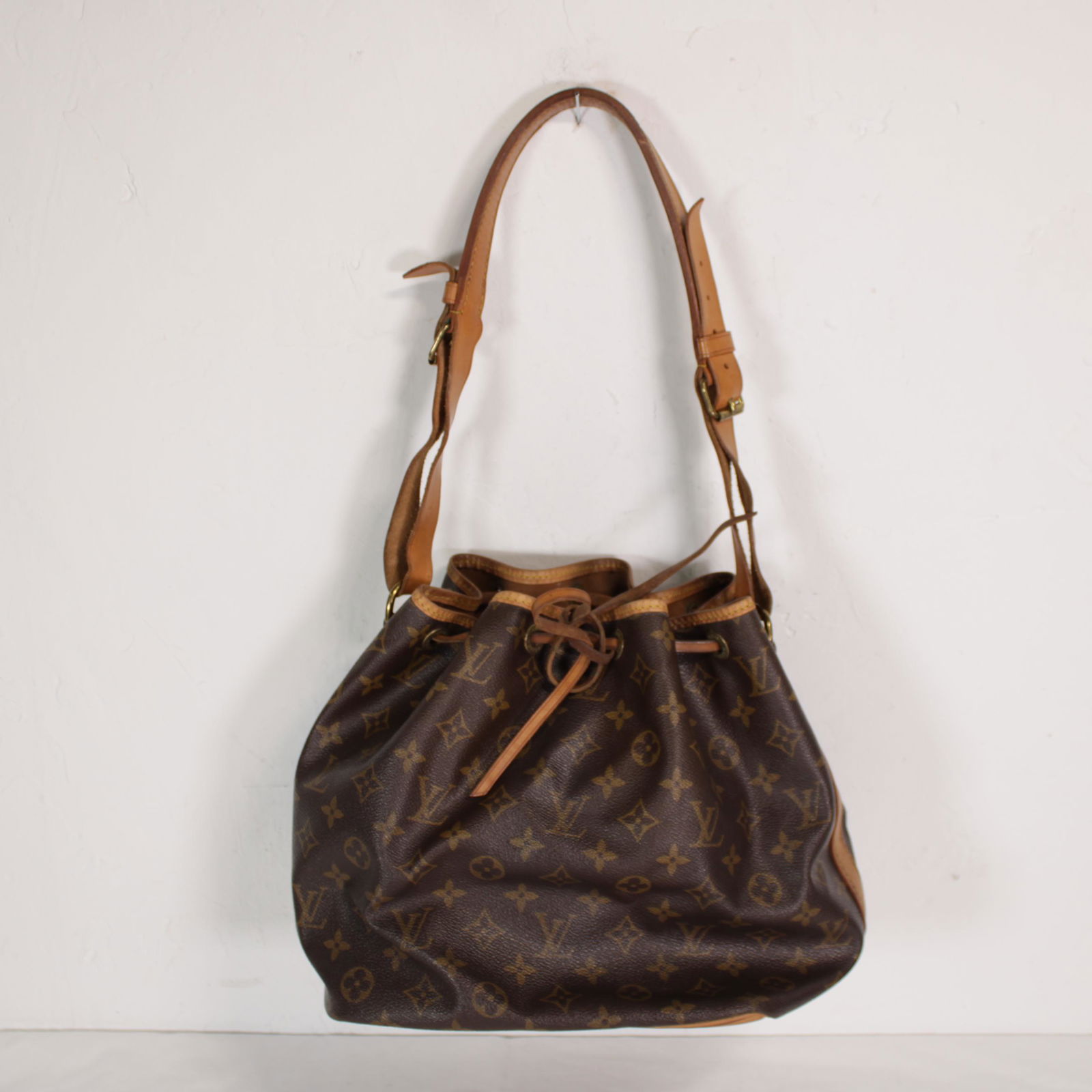 Louis Vuitton Noe PM in Monogram Canvas: Genuine Pre-Owned Louis Vuitton Noe PM in Brown Monogram Canvas in B condition. Date Code is 861MI. Measurements: 24*26*18cm (Length * Height * Width). This lot includes a certificate of authenticity.