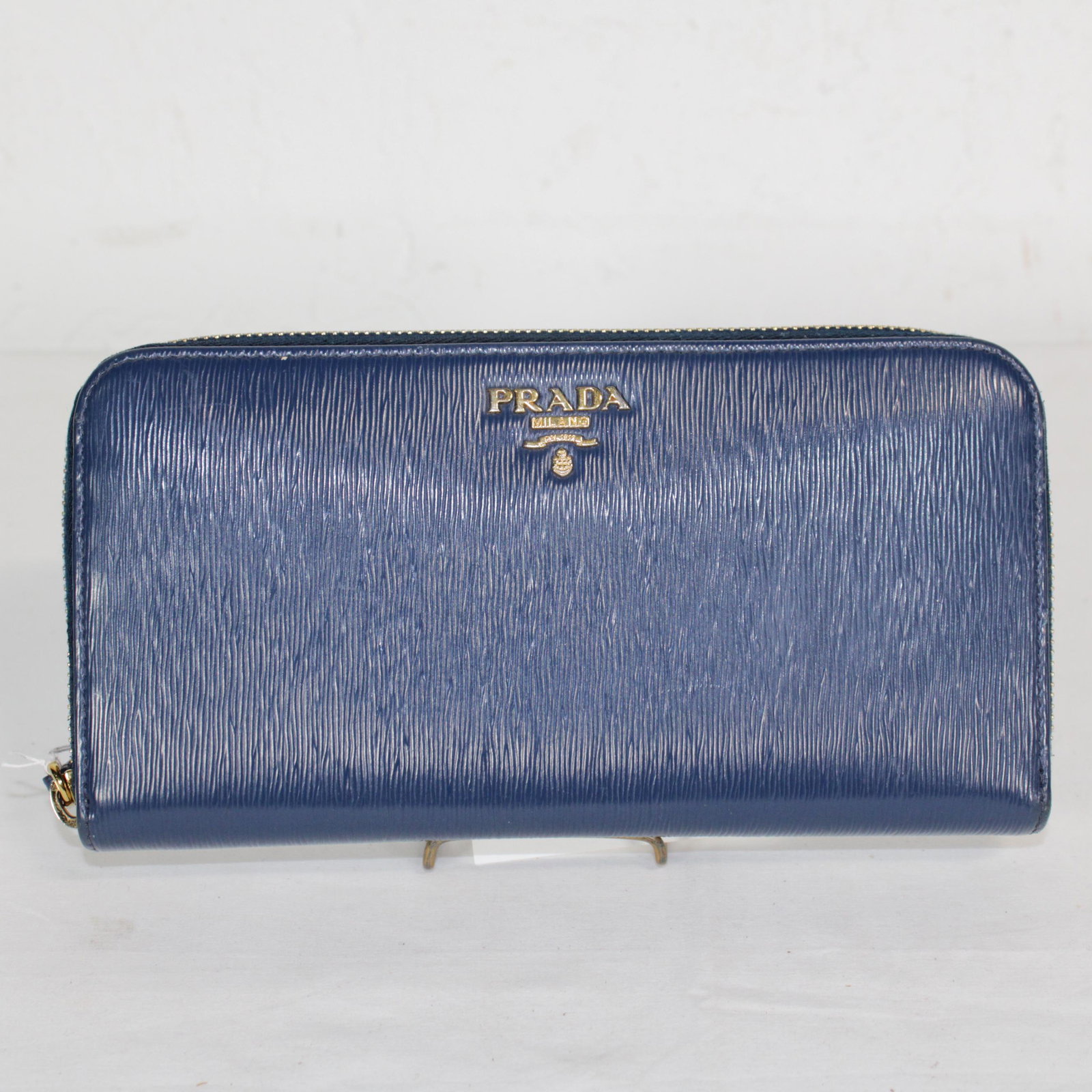Prada Round Zipper Long Wallet in Striped Embossed: Genuine Pre-Owned Prada Round Zipper Long Wallet in Navy Blue Striped Embossed Leather in A condition. Date Code is N/A This lot includes Box. Measurements: 20*10*3cm (Length * Height * Width). This l