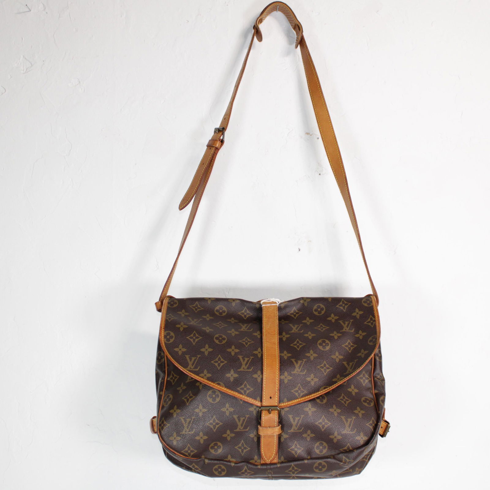Louis Vuitton Saumur 30 in Monogram Canvas: Genuine Pre-Owned Louis Vuitton Saumur 30 in Brown Monogram Canvas in AB condition. Date Code is 884VI. Measurements: 30*27*17 (Length * Height * Width). This lot includes a certificate of authenticit