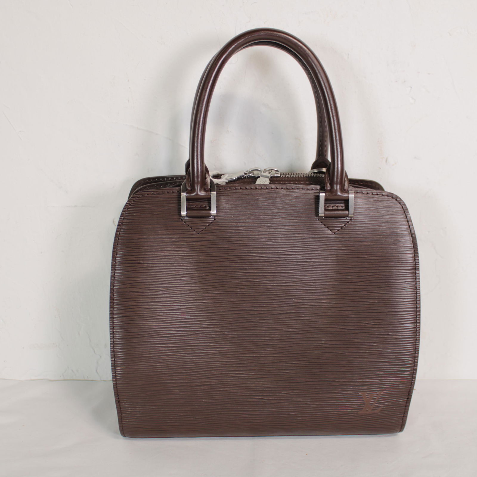 Louis Vuitton Pont-Neuf in Dark Brown Leather Epi: Genuine Pre-Owned Louis Vuitton Pont-Neuf in Dark Brown Epi in AA condition. Date Code is MI1003. Measurements: 24*22*10cm (Length * Height * Width). This lot includes a certificate of authenticity.