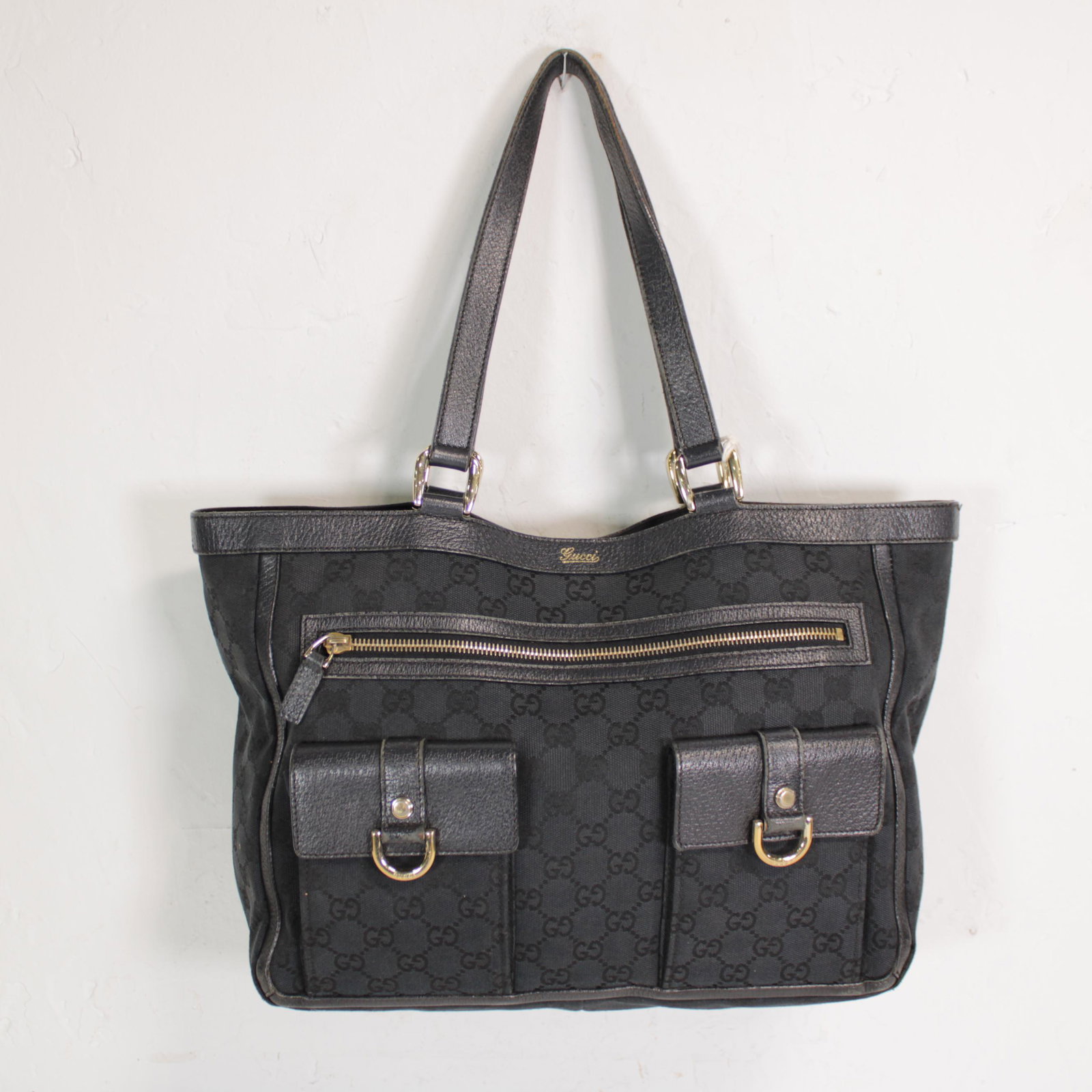 Gucci Abbey Pocket Tote in Monogrammed Canvas: Genuine Pre-Owned Gucci Abbey Pocket Tote in Black Monogrammed Canvas in B condition. Date Code is 146247-001013. Measurements: 33*25*10cm (Length * Height * Width). This lot includes a certificate of