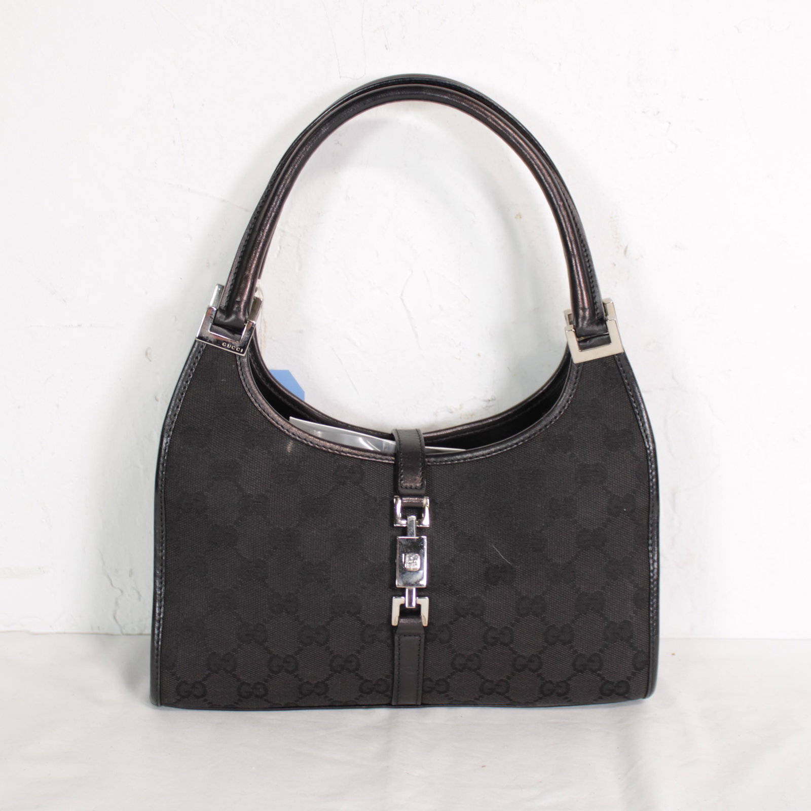 Gucci Jackie in Monogrammed Canvas: Genuine Pre-Owned Gucci Jackie in Black Monogrammed Canvas in A condition. Date Code is 002.10682404 This lot includes Dustbag. Measurements: 26*14*7cm (Length * Height * Width). This lot includes a c