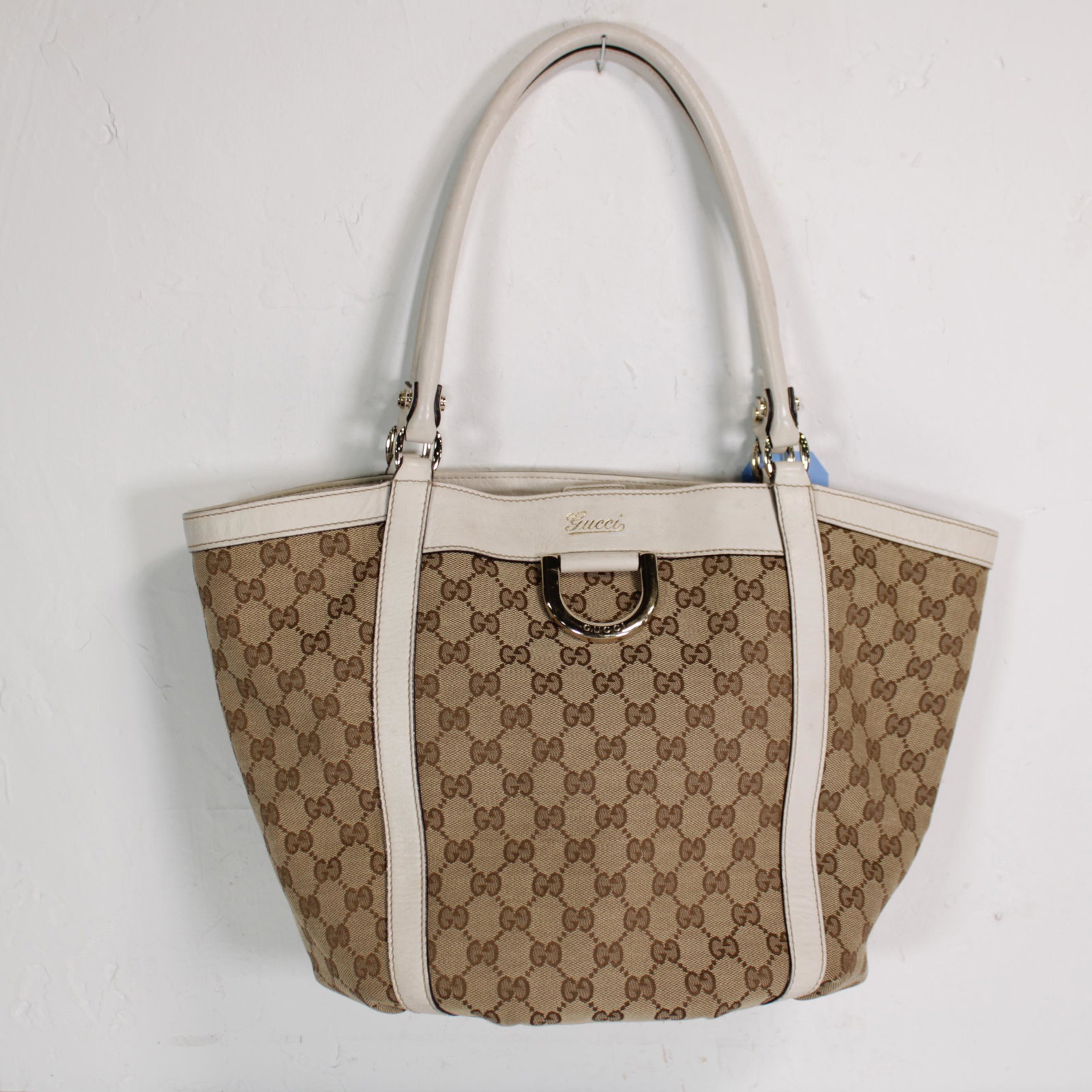 Gucci D-Ring Medium Tote in Monogrammed Canvas: Genuine Pre-Owned Gucci D-Ring Medium Tote in Brown/Beige Monogrammed Canvas in AB condition. Date Code is 211982/002122. Measurements: 25*30*13cm (Length * Height * Width). This lot includes a certif