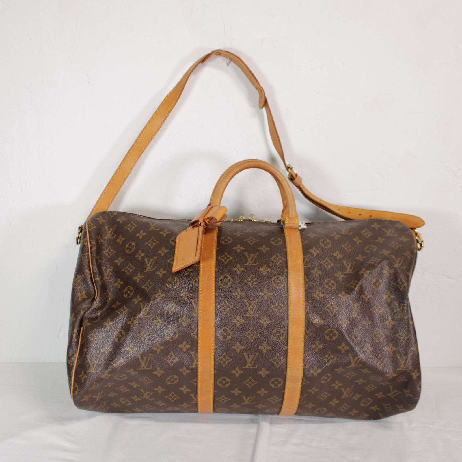 Louis Vuitton Keepall Bandouliere 55 in Monogram Canvas: Genuine Pre-Owned Louis Vuitton Keepall Bandouliere 55 in Brown Monogram Canvas in B condition. Date Code is VI0962 This lot includes Strap, Luggage Tag, Handle Strap. Measurements: 55*28*25cm (Length