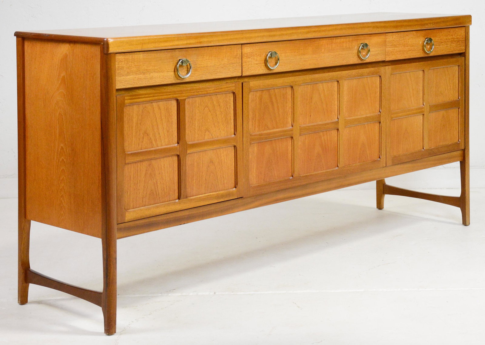 Mid Century Modern Teak Sideboard by Nathan Furniture: This Danish Modern Style Teak Credenza is made by Mid Century Modern Furniture Maker Nathan & features brass colored pulls . 33 in tall x 72 x 18