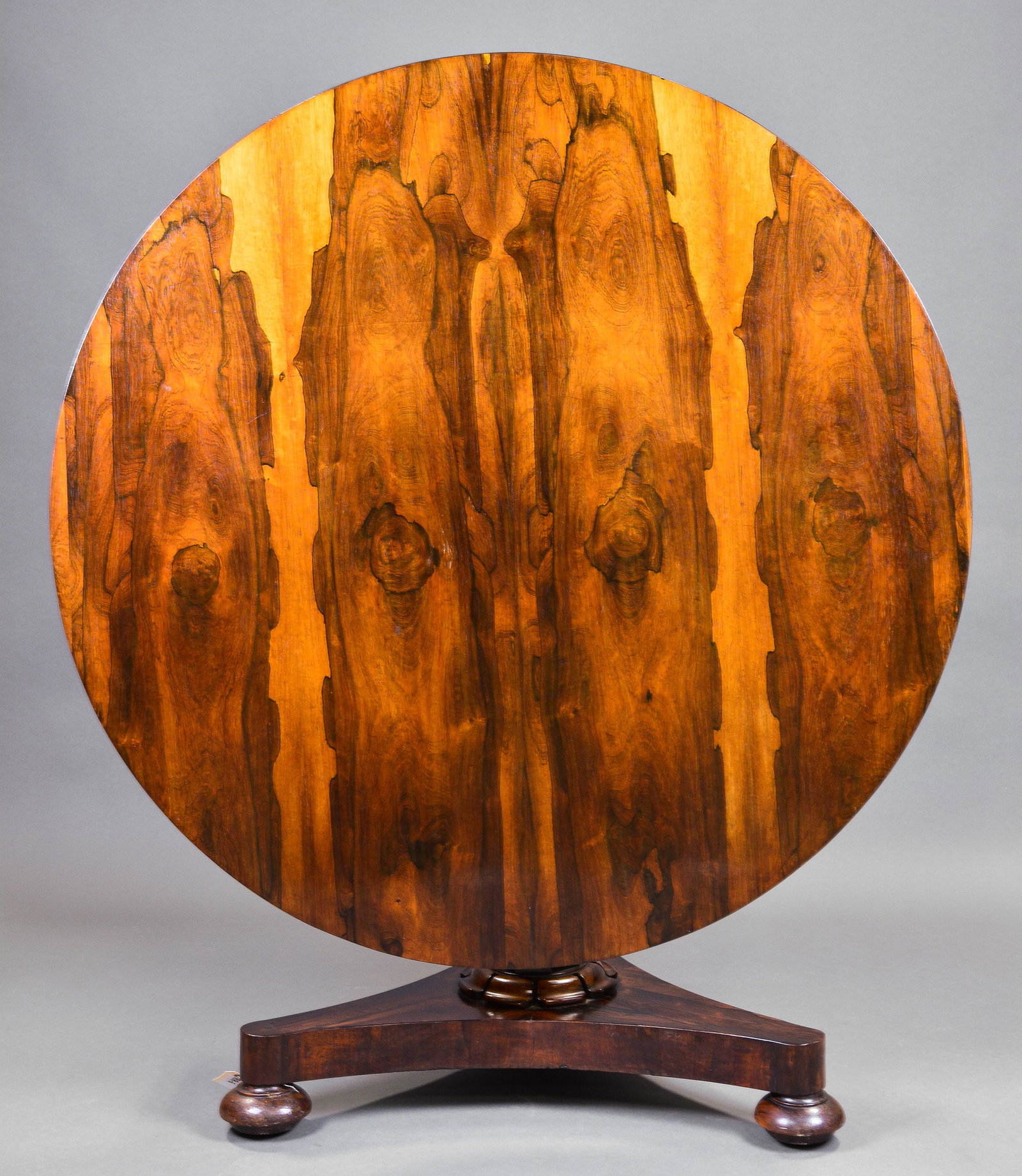 Rosewood Round Pedestal Base Entry / Tilt Top Table: English Rosewood Circular Center / Entry Table with red columnar design supported by a figured triparte base and bun feet - 29 in tall x 49 inch diameter