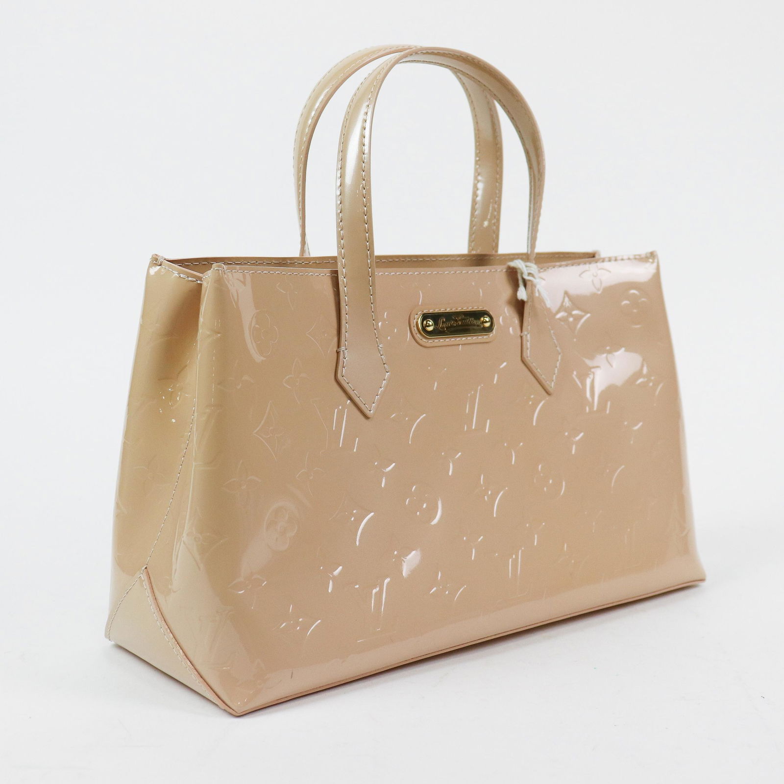 Louis Vuitton Wilshire PM in Monogram Vernis: Genuine Pre-Owned Louis Vuitton Wilshire PM in Beige Monogram Vernis in A condition. Date Code is SN4079. Measurements: 30*17,5*11cm (Length * Height * Width). This lot includes a certificate of authe
