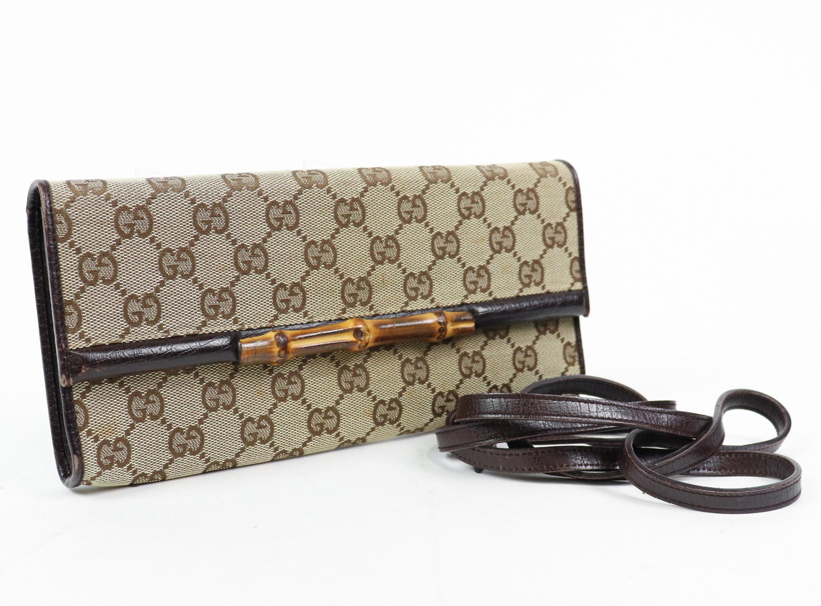 Gucci Vintage Bamboo Clutch in Monogrammed Canvas: Genuine Pre-Owned Gucci Vintage Bamboo Clutch in Beige/Brown Monogrammed Canvas in AB condition. Date Code is 117594/0950 This lot includes Strap. Measurements: 24,5*3*11,5cm (Length * Height * Width)