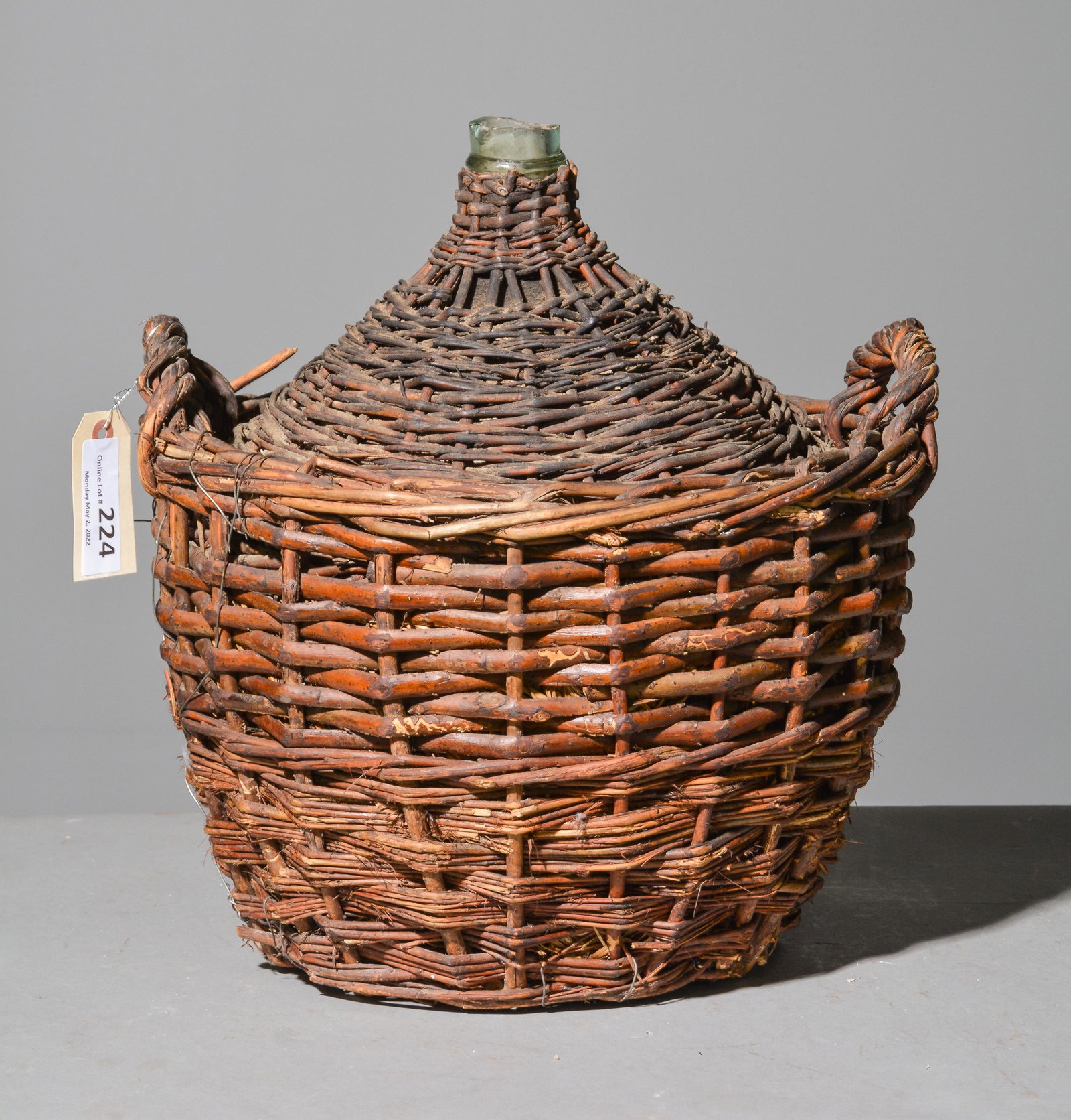 Glass Bottle in Wicker Basket: Glass Bottle in Wicker Basket - 17 in tall x 16 inch diameter