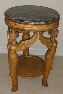 Circular 19th C. Empire Style Carved Giltwood Pedes: Turn-of-century French second empire style gilt wood; round black and white marble top caryarids with cloven hoof feet. Lower shelf. Very finely carved and detailed. 20" diameter x 30" high.