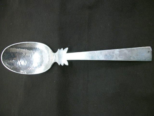Wm Spratling Sterling Serving Spoon: the bowl having a hammered finish in the Martele' style, the bowl end of the handle with 3 curved projections on each side, bearing the early Print Circle Mark, circa 1940, 9.5 in length, weight appro