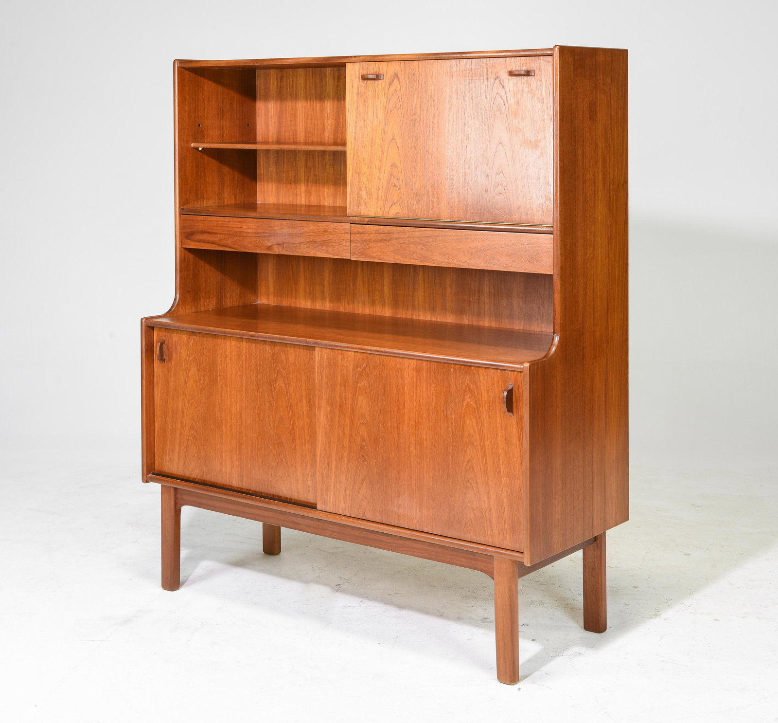 Mid Century Modern Cocktail Cabinet - Nathan: This Danish Modern Style hutch / High board is from England, likely by Nathan Furniture co. It has a drop down cocktail section, two hidden drawers and sliding doors to the bottom. - 55.5 in tall x 48
