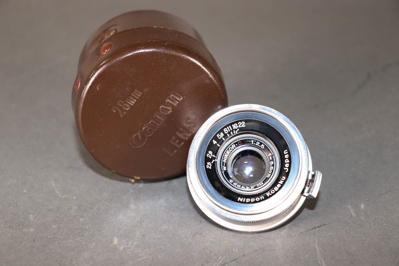 W-Nikkor 1:2.5 3.5cm Lens inside Canon Lens Leather Case: Item: W-Nikkor 1:2.5 3.5cm Lens inside Canon Lens Leather CaseBrand: Nippon KogakuModel/Serial Number: