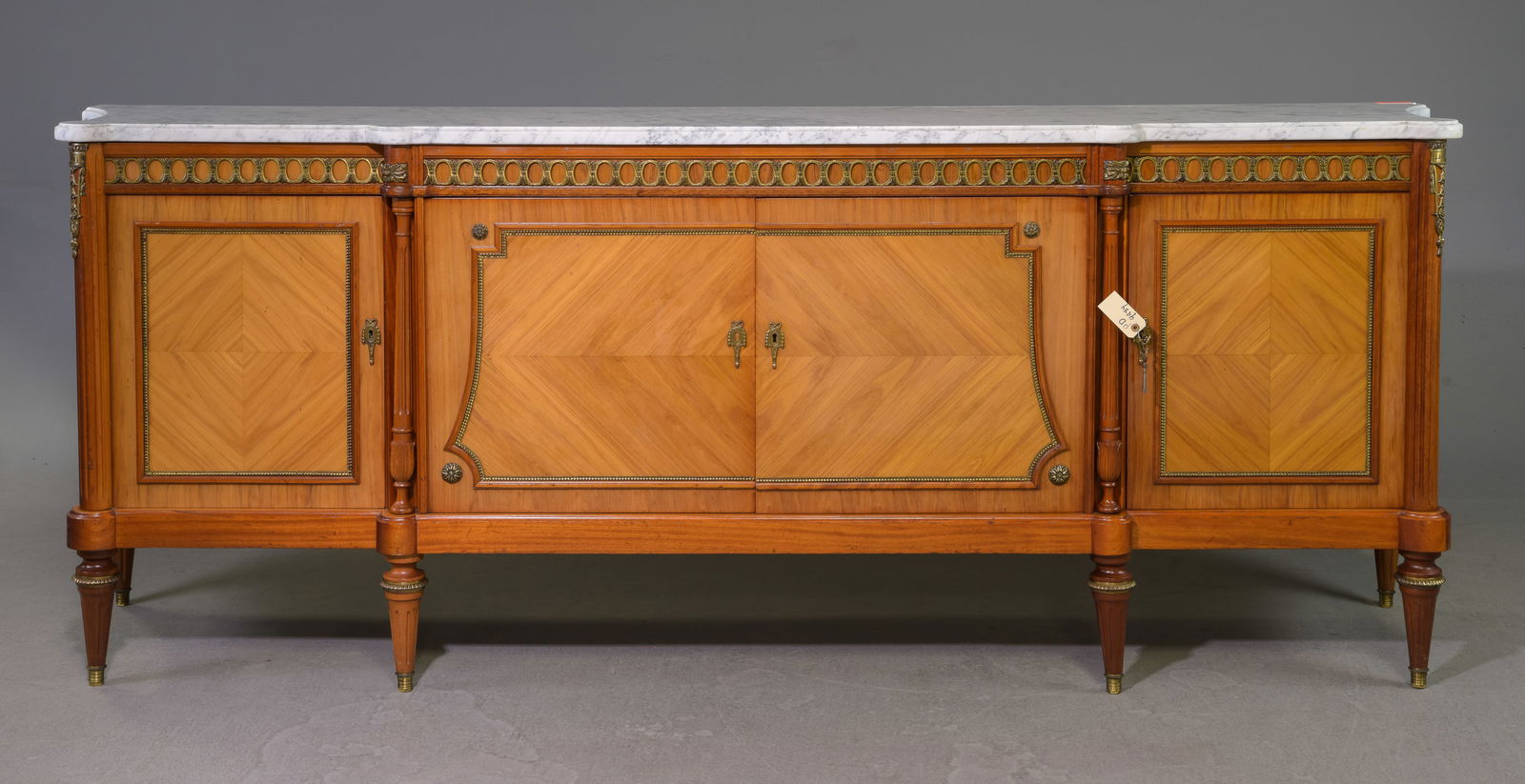 Louis XVI Style White Marble Top Sideboard: French Louis XVI Style White Marble Top Concaved Sided Sideboard / Enfilade with Gilded Ormolu Adornments - 39.25 in tall x 102.5 x 23.5