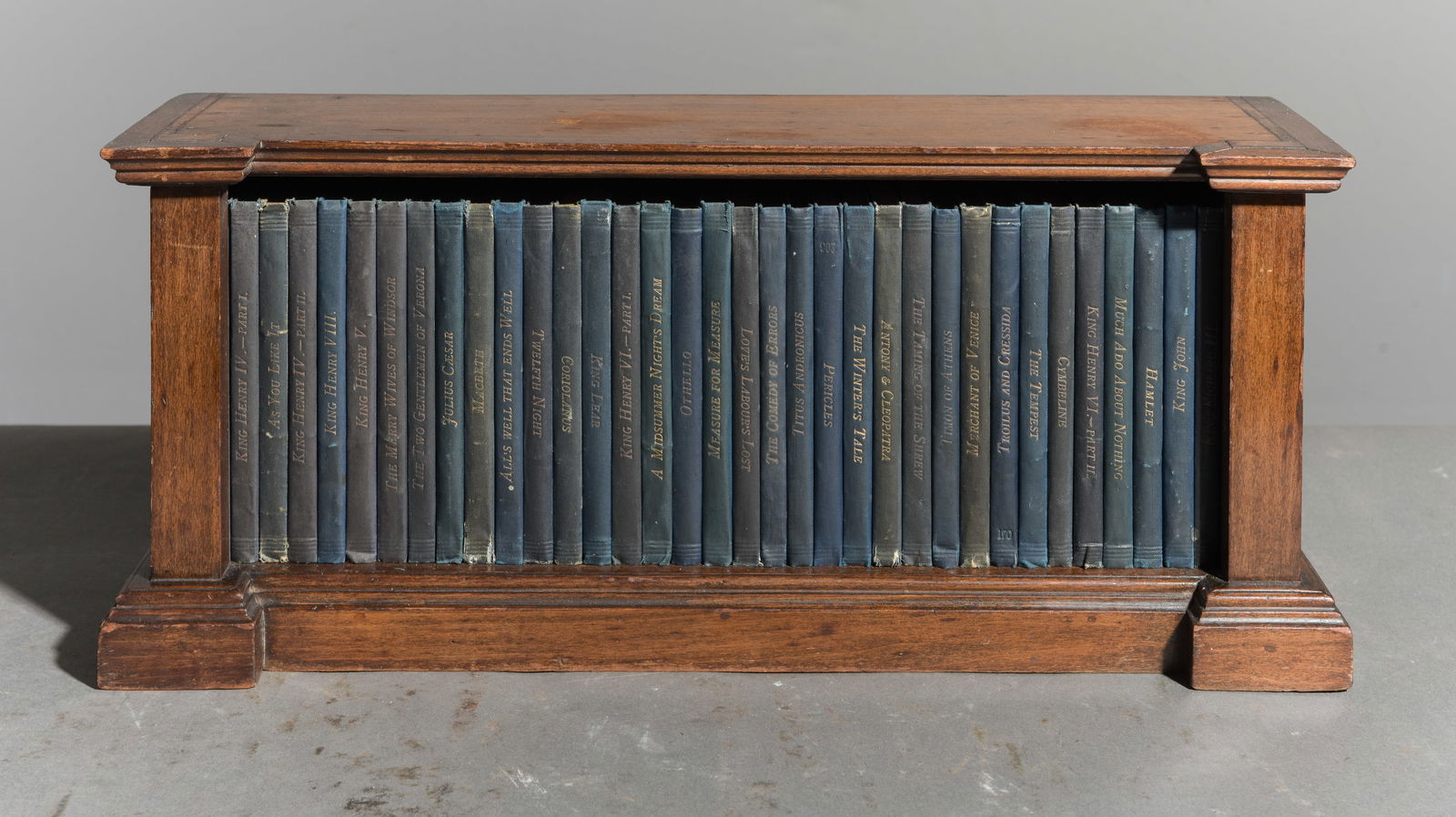 34 Assorted English Books / Novels in Oak Rack: 34 Assorted Petite English Books / Novels in Oak Rack - 8.5 in tall x 19 x 6 - Some titles are "King Lear", "King Henry VI" part 1, "The Merry Wives of Windsor", "King Henry VIII", "Alls Well That