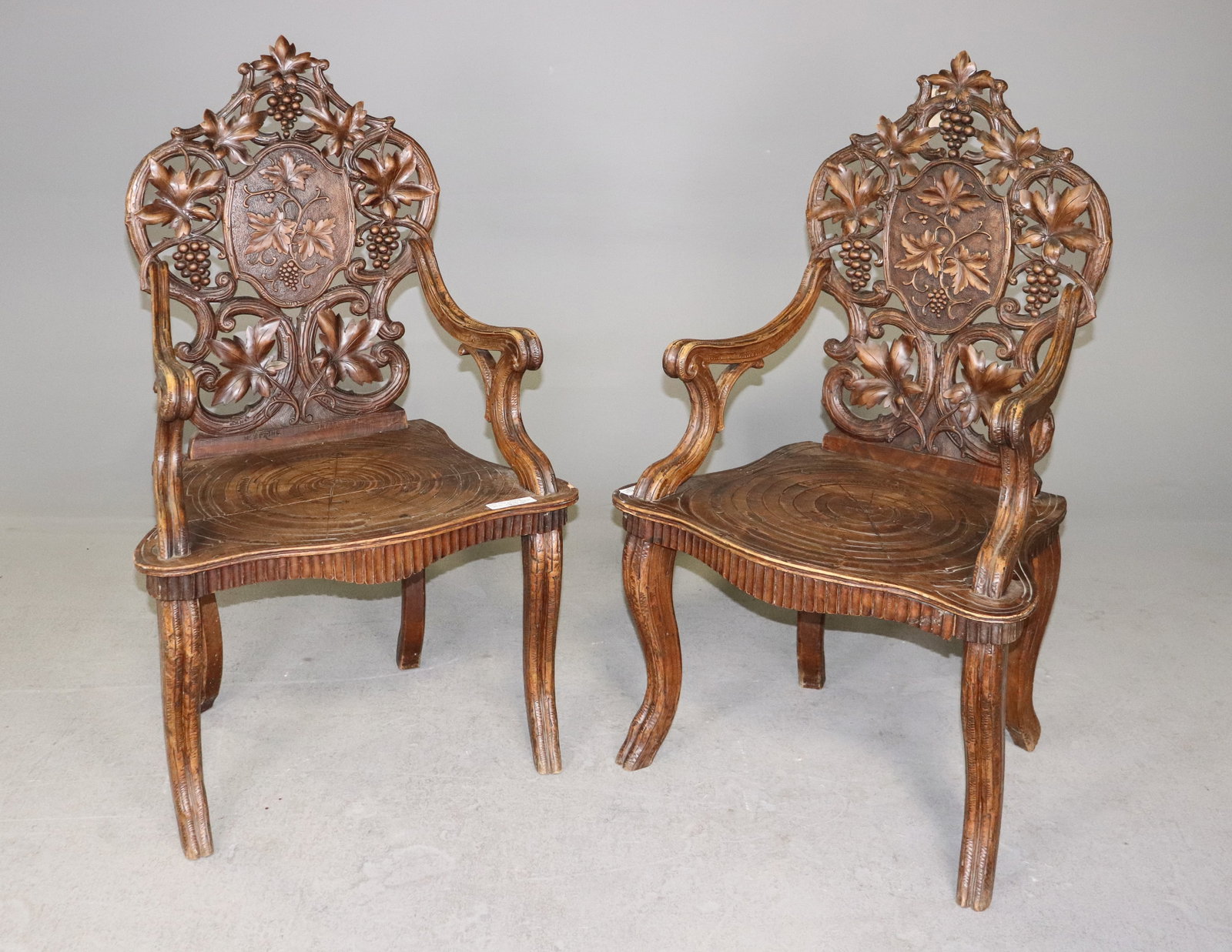Pair Of Black Forest Carved Arm Chairs: Pair Of Black Forest Carved Arm Chairs - 47 in tall x 27 x 23, seat height is 18 in