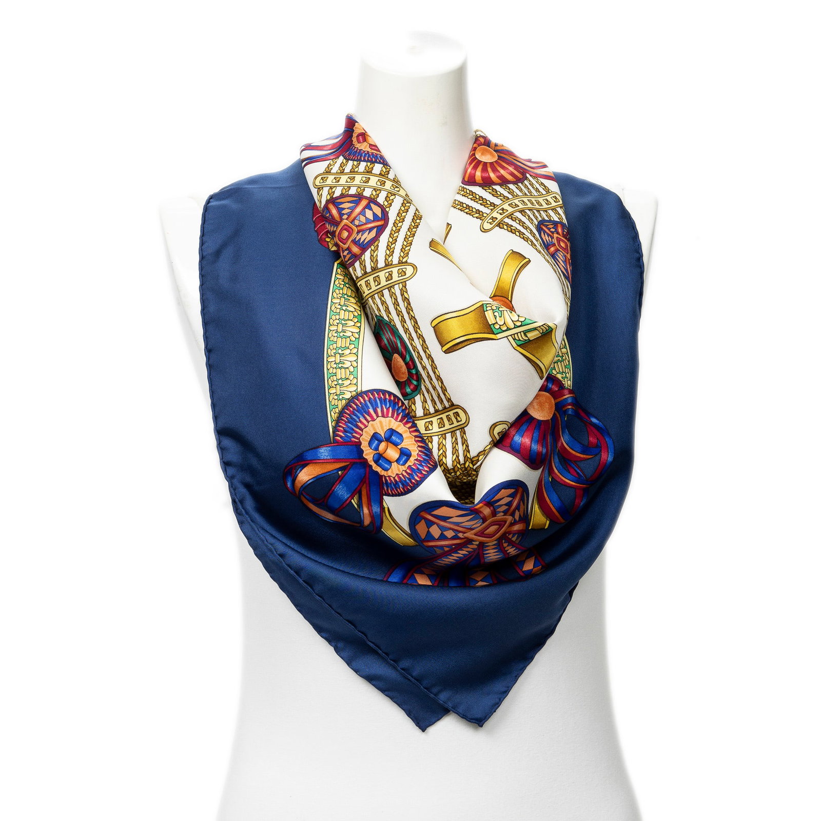 Hermes Scarf- Les Rubans Du Cheval by Joachim Metz: Genuine Pre-Owned Hermes Scarf in Navy/Gold/Red 100% Twill Silk in A condition. Pattern / Title is Les Rubans Du Cheval by Joachim Metz Measurements: 90*90cm (Length * Height * Width). This lot includ