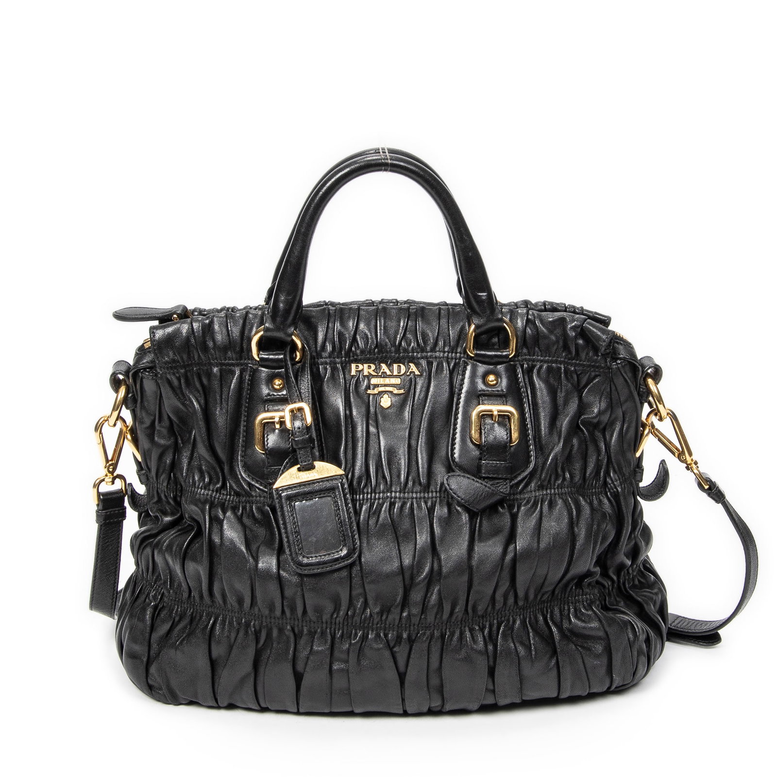 Prada Pleated Convertible Buckle Tote: Genuine Pre-Owned Prada Pleated Convertible Buckle Tote in Black Nappa Gaufre Leather made in Italy in A condition. Date Code is Measurements: 32*29*16cm (Length * Height * Width). This lot includes a