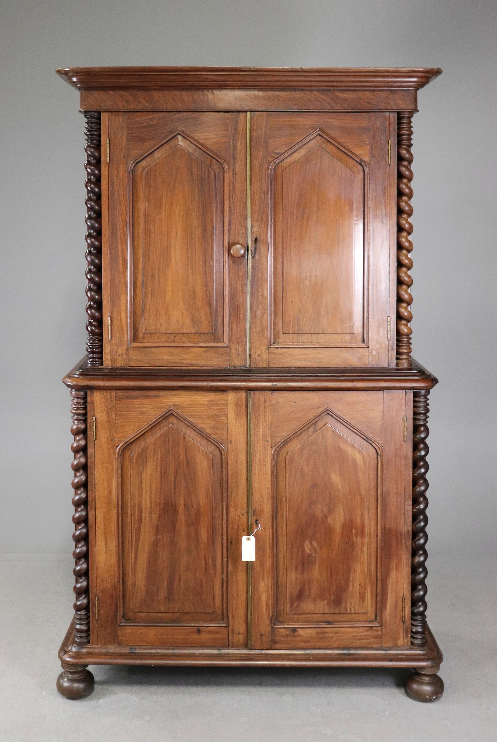 British Rosewood Linen Press With Twisted Columns: British Rosewood Two Piece Linen Press With Twisted Columns on oversize bun feet with brass interior hardware, this lot includes a key. - 81 in tall x 48 x 22.5