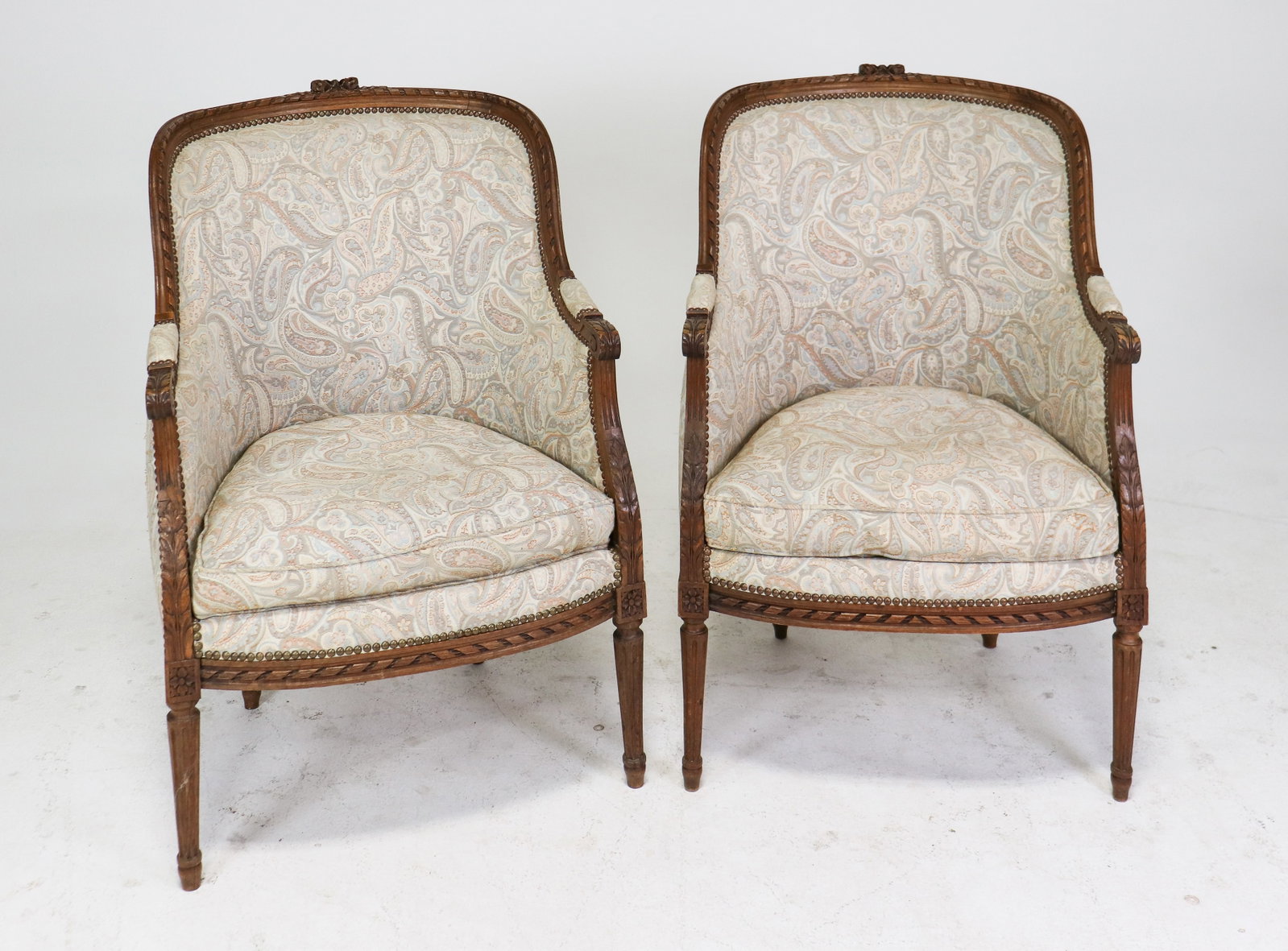 Pair of French Louis XVI Style Bergere Chairs: Pair of French Walnut Louis XVI Style Bergere Chairs with Light Paisley Upholstery - 39.5 in tall x 26.5 x 27 - Seat Height is 18 in tall