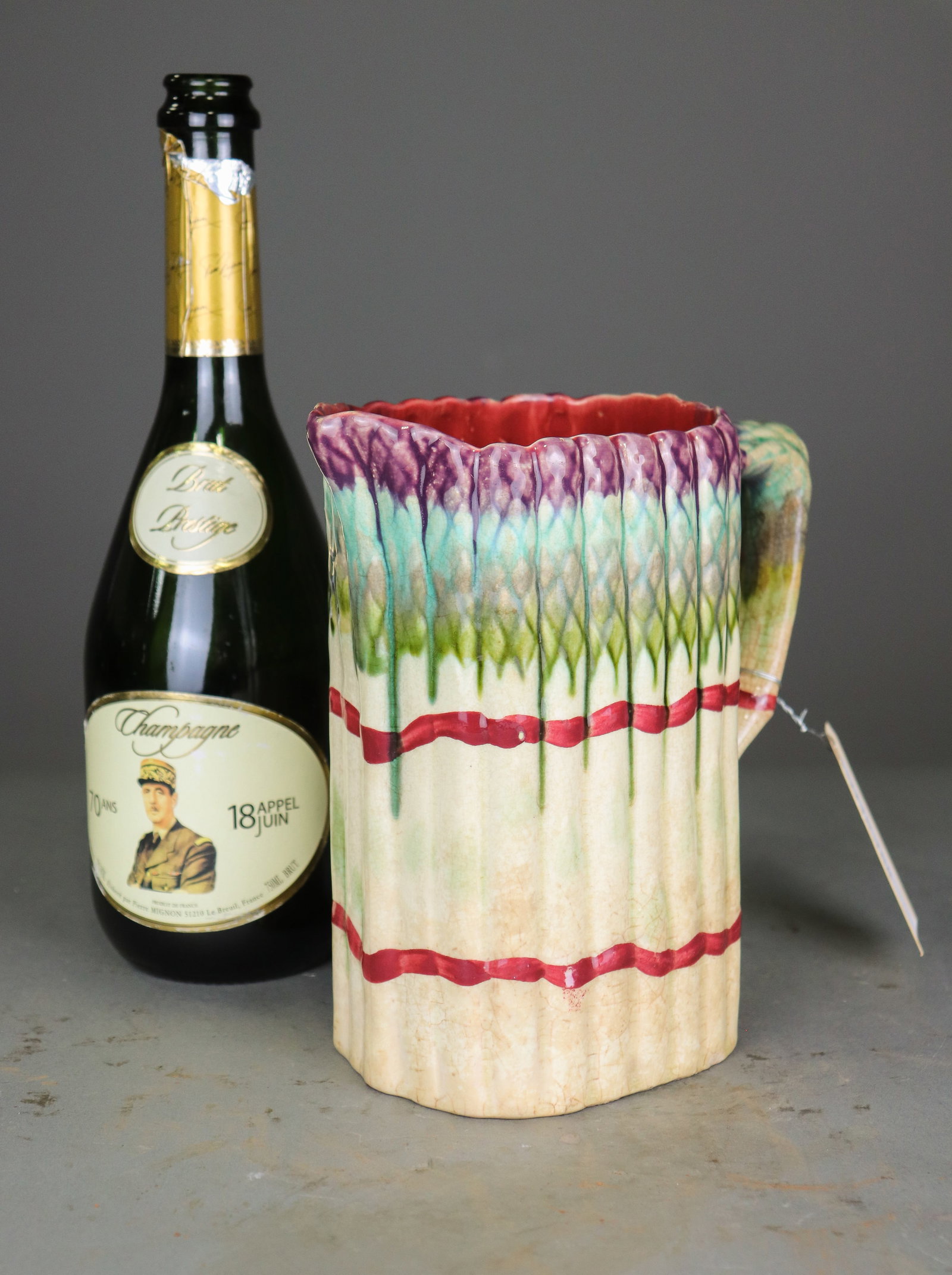 Antique French Majolica Asparagus Pitcher: Antique French majolica pitcher modeled as a bundle of asparagus with colorful purple, green and cream glazes and a naturalistic curved handle. Maker and age unknown. 8 in tall x 7.5 x 4