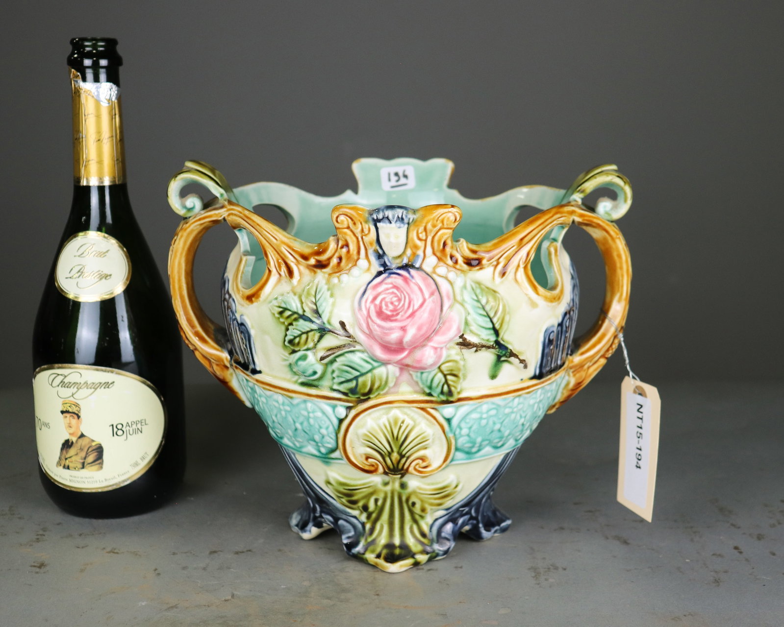French Majolica Floral Double Handle Jardiniere No. 385: French majolica jardiniere with relief molded roses, scrolling handles and ornate footed base. Colorful turquoise, green, blue, pink and ochre glazes. Impressed model number 385 to underside. 9 in tal