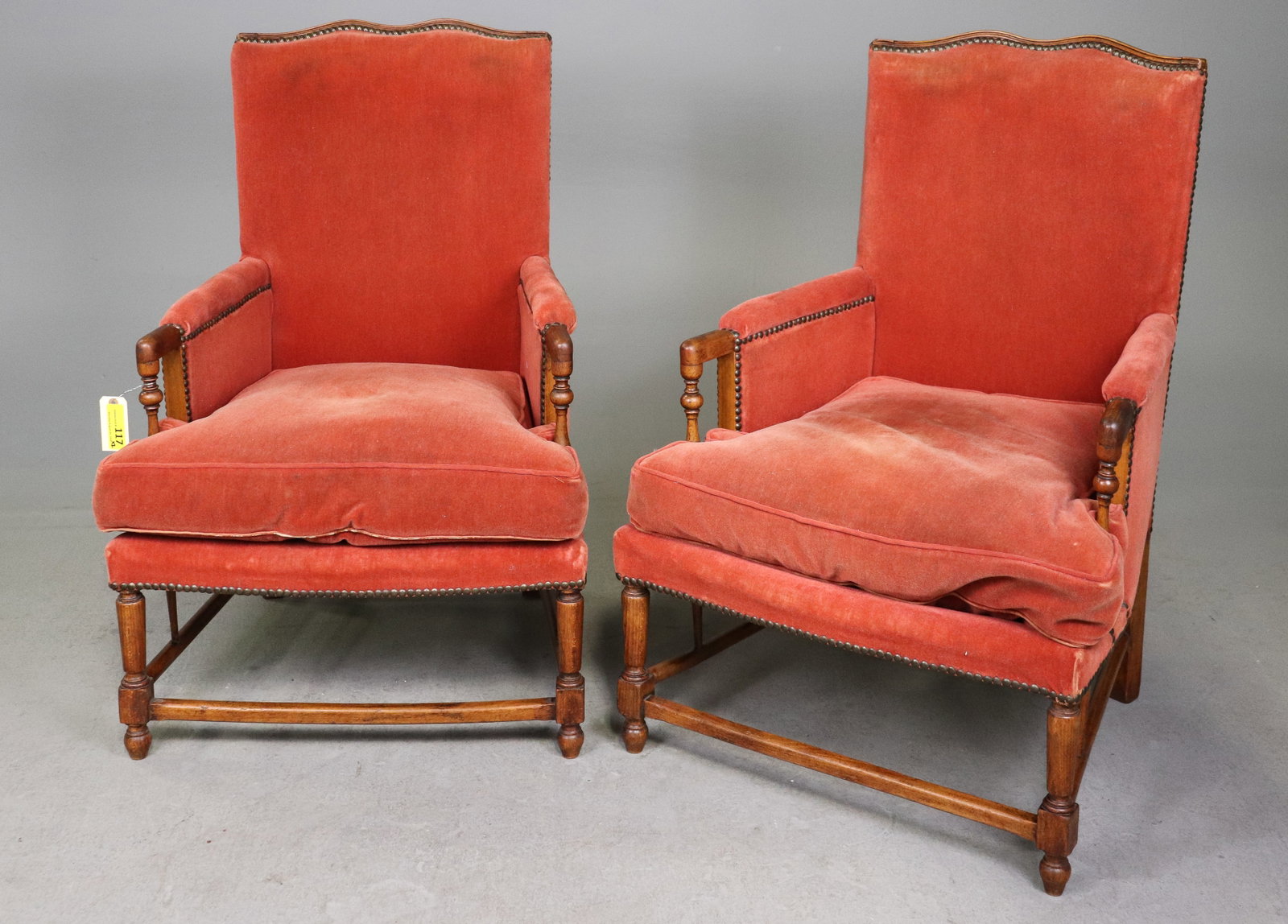 Pair French Style Red Velvet Upholstered Armchairs: Pair of French style armchairs with carved wood frames, red velvet upholstery, loose seat cushions and nail head trim. 37.25 in tall x 25 x 24 seat height is 17 in