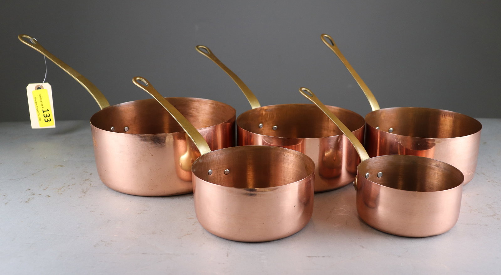 Set of 5 French Copper Saucepans with Brass Handles: Set of five graduated French copper saucepans featuring long brass handles with distinctive loop-form ends. Classic professional French cookware with warm aged copper surfaces 3.5 in tall x 15 x 8 - t