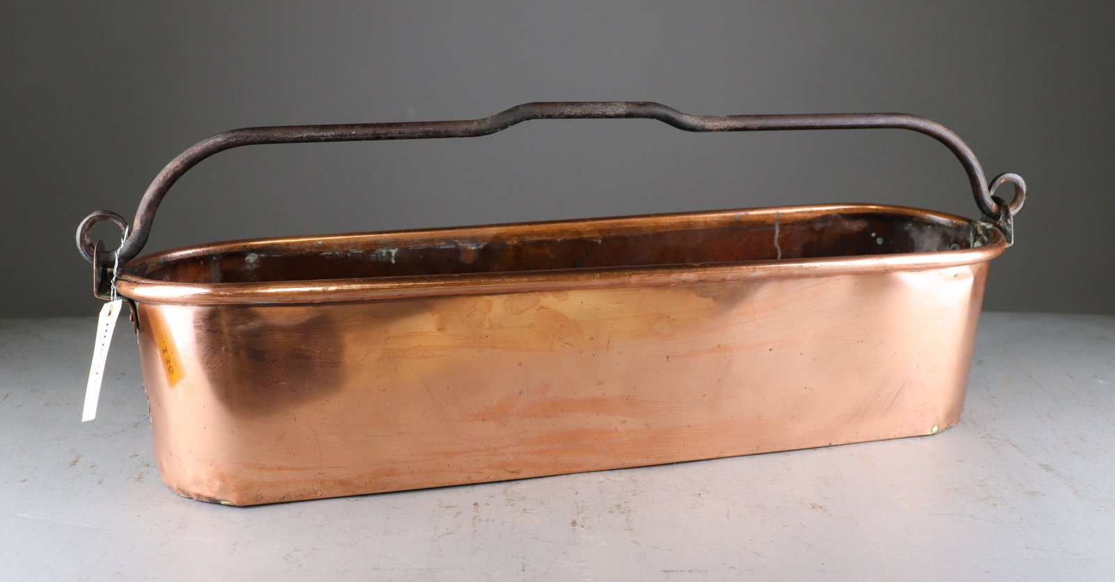 Large French Copper Fish Poacher: Large antique French copper fish poacher of elongated oval form with heavy iron swing handle and loop-form end mounts. Substantial traditional French cookware with attractive aged copper surface. 11 i