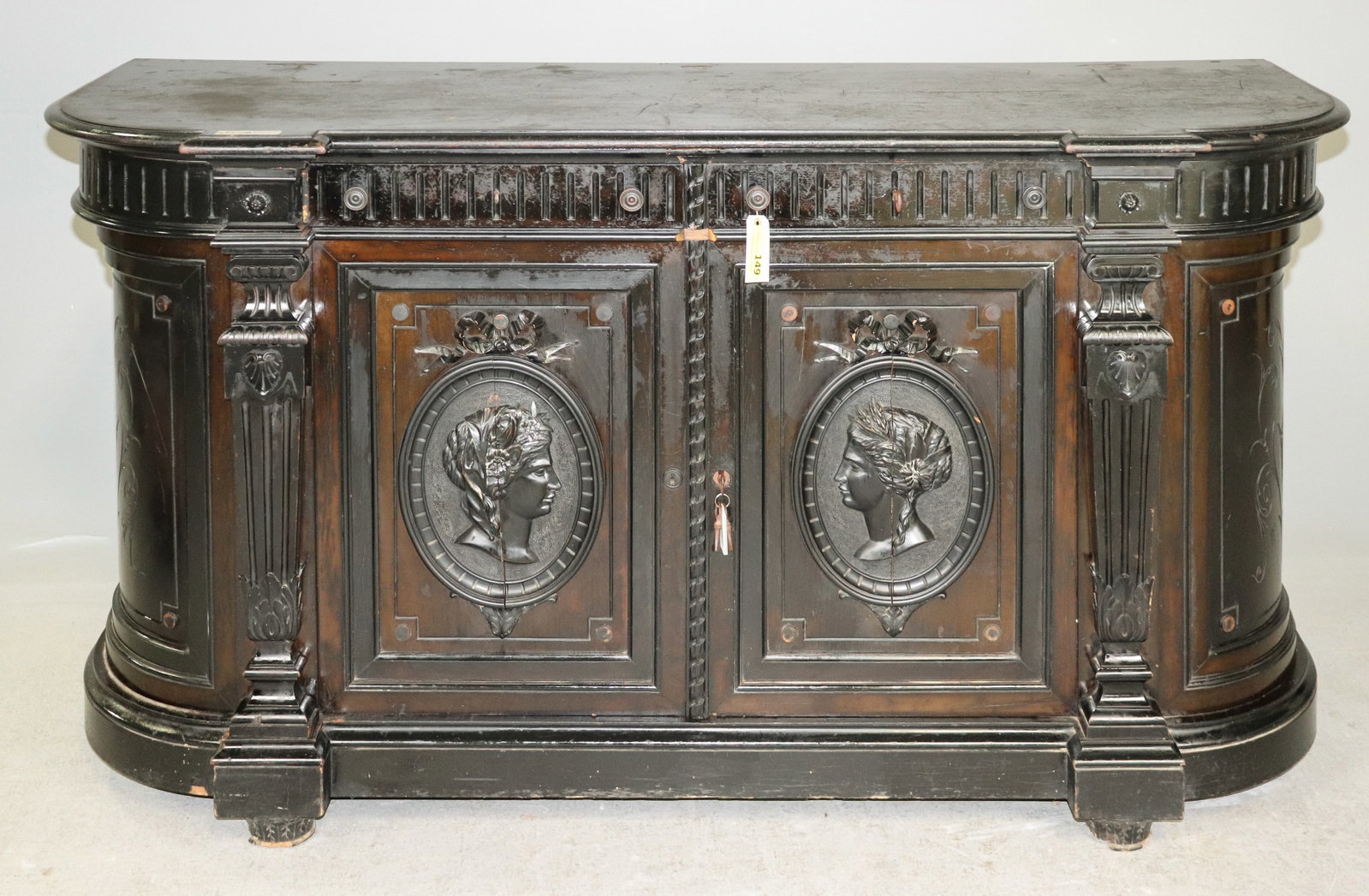 French Ebonized Renaissance Revival Carved Sideboard Cabinet: French ebonized wood sideboard or cabinet with elaborate Renaissance Revival detailing. Features a shaped top, architectural columns, carved frieze and two paneled doors decorated with raised classica