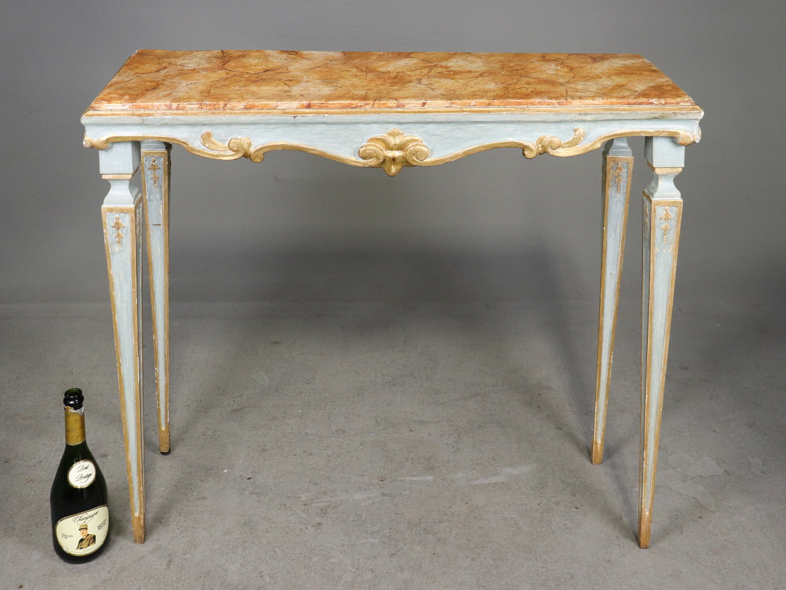 Florentine Style Painted Gilt Console Table: Italian Florentine style console table with faux marble painted top, blue painted finish, gilt accents, carved apron and slender tapered legs. 33 in tall x 38 x 13.5