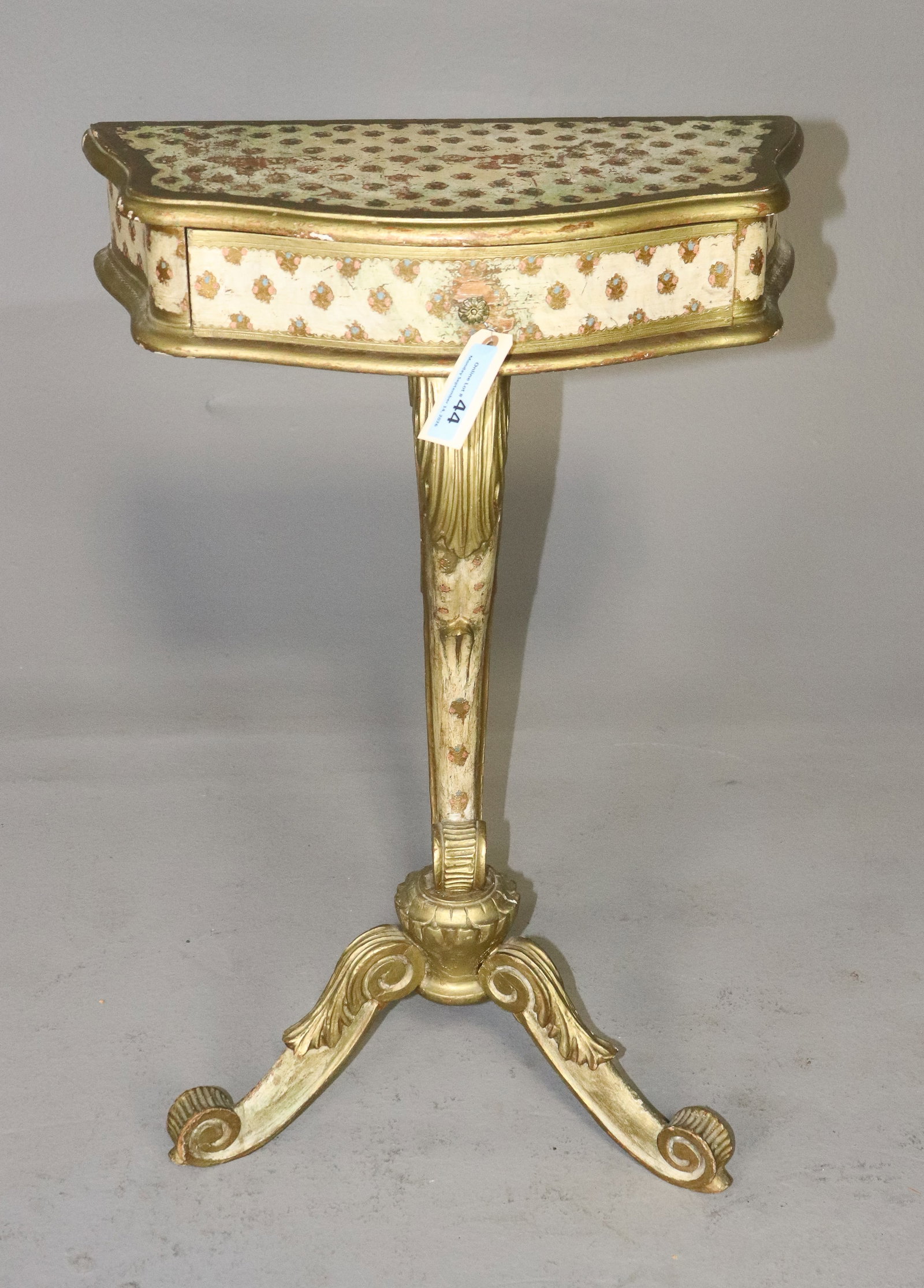 Italian Florentine Style Gilt Painted Tripod Table: Italian Florentine style gilt and painted work or occasional table featuring a shaped rectangular case decorated with repeating floral motifs and gilt borders. Raised on an ornate gilt metal pedestal 