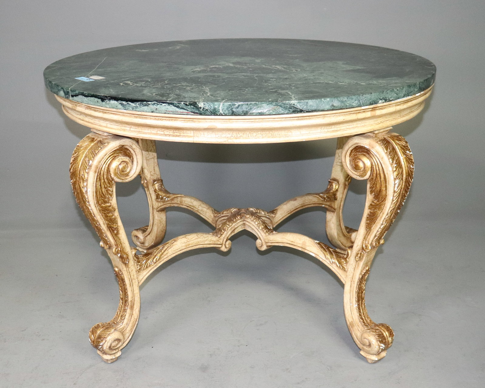 French Antique Louis XV Style Carved Giltwood Green Marble Center Table: French Antique Louis XV style center table featuring a circular green marble top over an elaborately carved and giltwood base. Raised on four boldly scrolling cabriole legs with carved acanthus and fo