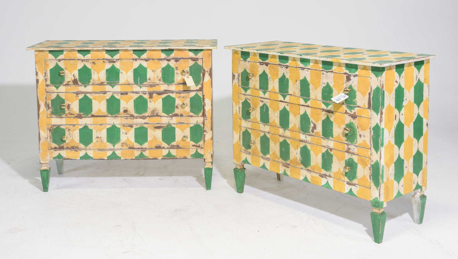 Pair Hand-Painted European Style Geometric Chests - Green & Yellow: Pair of European style three-drawer chests with bold hand-painted geometric decoration in green, mustard yellow and cream. The repeating dimensional motif covers the tops, fronts and sides, with brass